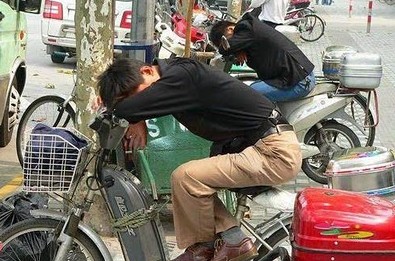 Chinos durmiendo en la moto