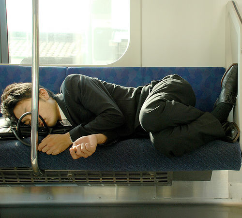 Chino durmiendo tumbado en el metro