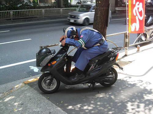 Chino durmiendo sobre la moto